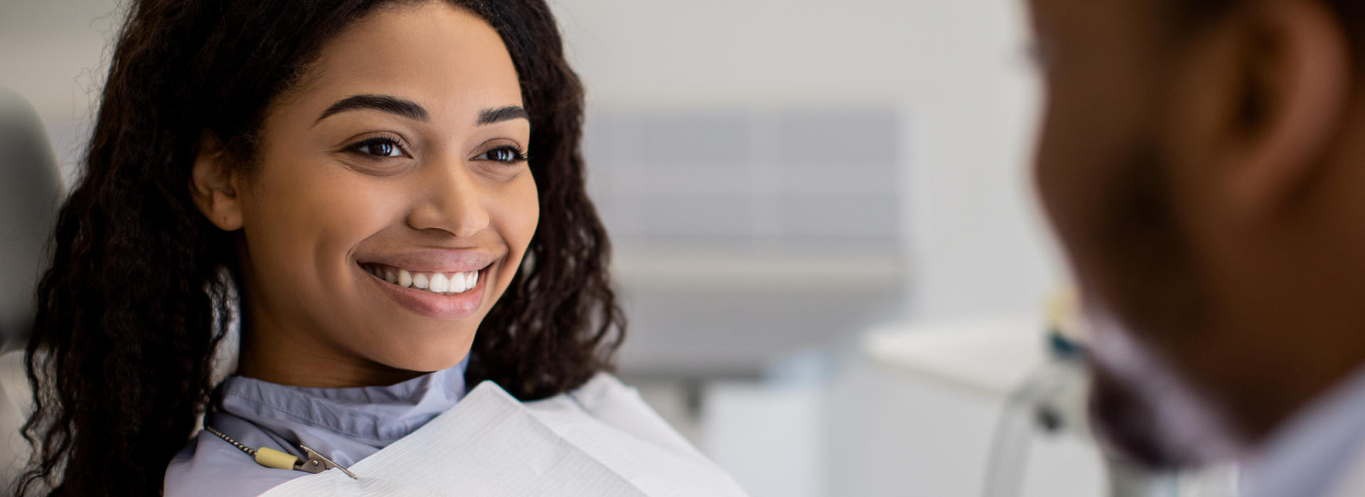 A woman is smiling after cosmetic dentistry.