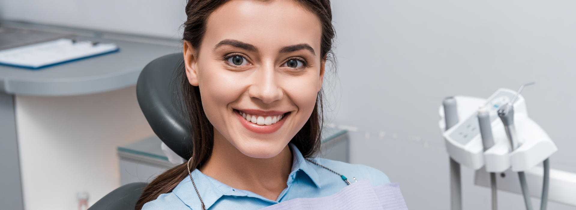 A woman is smiling after dental veneers.