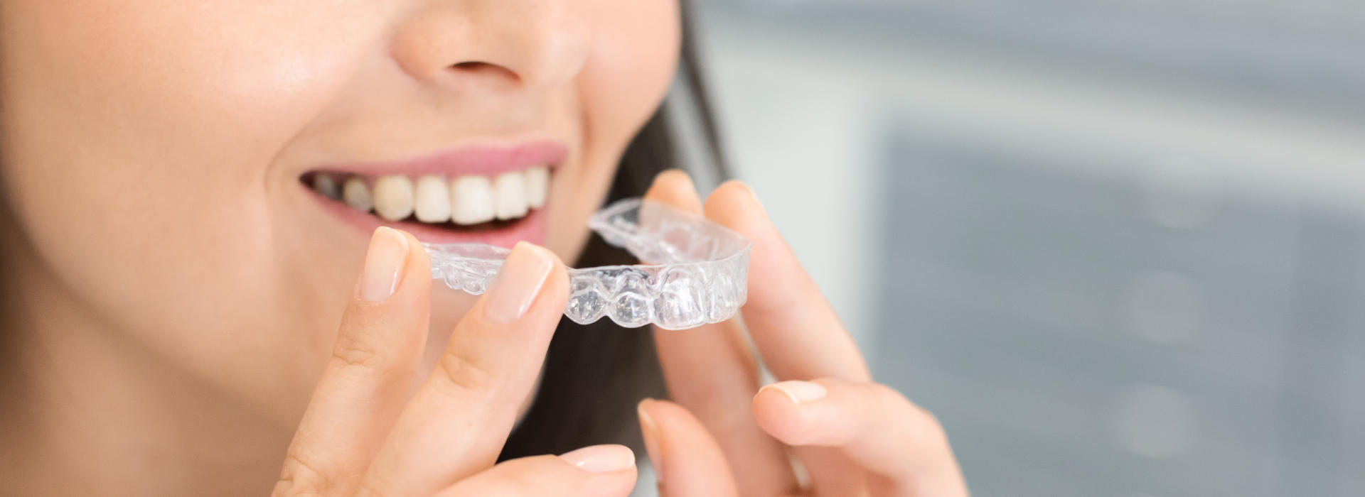 A woman is holding a invisalign clear aligners.